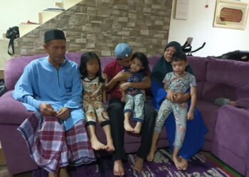 MOHD. YUSOF Mokhtar (tengah) bersama-sama bapa dan ibu mentuanya, Ahmad Rozi Latimin dan Saleha Ya serta anak-anaknya ditemui di Taman Kota Masai, Pasir Gudang.