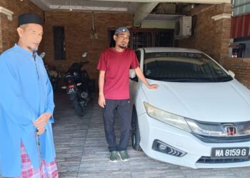 MOHD. YUSOF Mokhtar sambil diperhatikan bapa mentuanya, Ahmad Rozi Latimin menunjukkan kereta arwah isterinya di Kota Masai, Pasir Gudang.