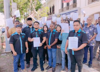 HISHAMUDDIN Hashim (tiga dari kiri) bersama mangsa skim pelaburan mesin air minuman layan diri menunjukkan surat aduan yang dihantar ke Pejabat SSM Melaka di Ayer Keroh, Melaka. - UTUSAN/MUHAMMAD SHAHIZAM TAZALI