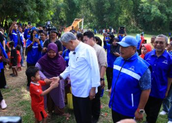 AHMAD Zahid Hamidi (kiri) beramah mesra dengan anak Orang Asli di Pos Pulat, Gua Musang, Kelantan hari ini-UTUSAN/KAMARUL BISMI KAMARUZAMAN