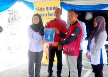 NAIB Presiden Yayasan Inovasi Malaysia (YIM), Nur Fadzlina Mahamad Razi (kiri) menyerahkan projek tukun inovasi kepada Pengerusi Nelayan Telok Mas, Khairul Anuar Abdul Gani di Pangkalan Nelayan Umbai, Jasin, Melaka. - UTUSAN/AMRAN MULUP