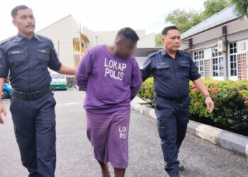 SUSPEK diiringi anggota polis ketika dibawa ke Mahkamah Majistret, Jasin, Melaka untuk permohonan reman. - UTUSAN/MUHAMMAD SHAHIZAM TAZALI