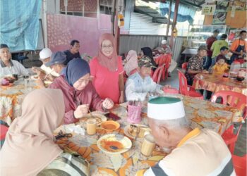 NORAINI Hamed (baju merah) melayan pelanggan yang datang bersarapan di kedainya di Pekan Benut, Pontian.