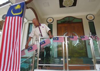 ABU Bakar Jusoh memasang Jalur Gemilang di rumahnya di Gua Musang, Kelantan. - UTUSAN/AIMUNI TUAN LAH