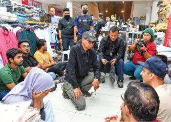 JAFRI Embok Taha memeriksa pekerja asing yang ditahan dalam serbuan dekat sebuah pusat beli belah terkemuka di Klang, Selangor, semalam. – UTUSAN / SYAKIR RADIN