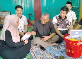 NOOR Farra Wahida Suhaimi (kiri) menerima sumbangan disampaikan Zulkifli Abdullah di Kampung Baru Nelayan, Tumpat, Kelantan, semalam. – UTUSAN/ROHANA ISMAIL