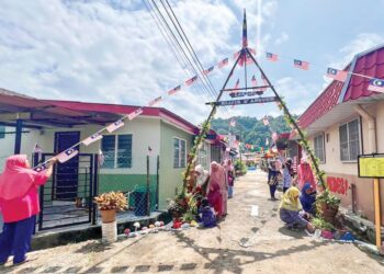 PENDUDUK berganding bahu menghias lorong belakang rumah sempena sambutan Bulan Kemerdekaan di Taman Semarak, Kuala Perlis, Perlis, semalam. – UTUSAN/ASYRAF MUHAMMAD