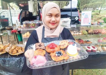 NURUL Najeerah Zainun Abidin menunjukkan pemanis mulut 
yang dijualnya di Pantai Bukit Keluang, Besut, Terengganu, semalam. – UTUSAN/WAN ZURATIKAH IFFAH WAN ZULKIFLI