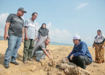 SEKUMPULAN penduduk termasuk waris penduduk asal perkampungan lama Mong Gajah menziarahi kawasan perkuburan lama berusia lebih 100 tahun yang timbul selepas air Tasik Pedu semakin surut ekoran musim panas dan kemarau, baru-baru ini. – UTUSAN/SHAHIR NOORDIN