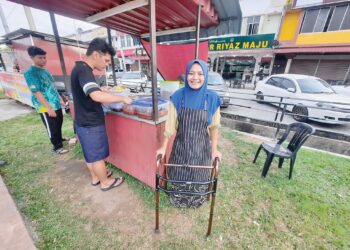 NURUL Wahida Jamaluddin bertongkat sambil berniaga nasi lemak di gerainya di Kampung Sungai Badak, Kulim.
