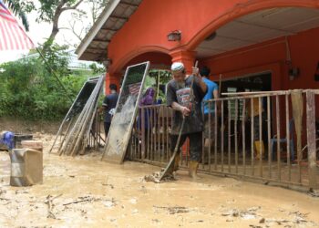 MANGSA banjir, Seffee Hussain membersihkan kawasan rumahnya yang dipenuhi lumpur akibat kejadian kepala air ketika tinjauan di Kampung Pasir, Ulu Slim, semalam. – UTUSAN/ZULFACHRI ZULKIFLI