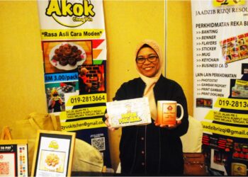YUSEIRINIE Ahmad menunjukkan sebahagian daripada produk pengeluarannya seperti cawan mug dan kad ucapan. - UTUSAN/AMRAN MULUP