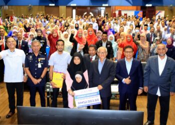 AMINUDDIN Adam (empat dari kanan) dan Wan Munadi (tiga dari kanan) menyerahkan Khairat Kematian Skim Emas YGMB kepada keluarga Mohd. Fakhruzzaman pada Majlis Ceramah Anti-Scam di JPN Kelantan, Tunjong di Kota Bharu, Kelantan hari ini-UTUSAN/ROSMIZAN RESDI
