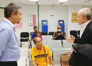IDHAM Wazir (kiri) mendengar penerangan peguamnya, Kamaruddin Ahmad (kanan) sebelum memasuki kamar Mahkamah Tinggi Sivil, Johor Bahru.