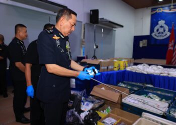 MUHAMAD Zaki Harun (kiri) memeriksa dadah yang akan dilupuskan semasa sidang media di Ibu Pejabat Polis Kontinjen (IPK) Kelantan, Kota Bharu, Kelantan hari ini-UTUSAN/KAMARUL BISMI KAMARUZAMAN.