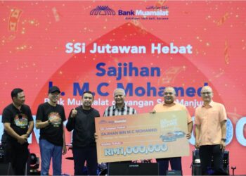 SAJIHAN  M.C. MOHAMED bersama menerima replika cek SSi Muamalat Bank bernilai RM1 juta yang diterima pada Majlis Penyampaian Hadiah SSi Edisi Gemilang 25 Tahun di Kuala Nerus, malam tadi. - UTUSAN/PUQTRA HAIRRY ROSLI