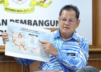 AZMAN Mahmood menunjukkan taburan purata hasil kawasan jelapang padi ketika sesi temubual berkenaan projek rintis pembajaan tepat jelapang padi di Wisma Tani, Putrajaya. - UTUSAN/FAISOL MUSTAFA