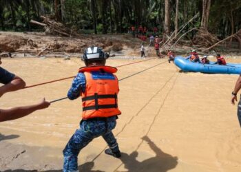 ANGGOTA bomba memindahkan mangsa yang terperangkap di Risda Eco Park di Slim River akibat kejadian kepala air yang berlaku semalam. - UTUSAN/IHSAN JBPM
