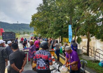 PENIAGA membuka gerai jualan di tepi Jalan Kuala Teriang disebabkan banjir melanda Pasar Awam Padang Matsirat di Langkawi. -UTUSAN/ NUR AMALINA AZMAN