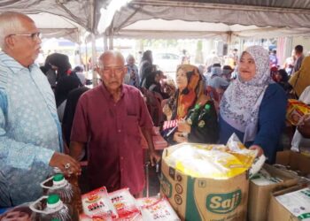 MAHFUZ Omar (kiri) bertemu masyarakat setempat yang mendapatkan barangan Jualan Rahmah sempena Program Kibar Jalur Gemilang di Masjid An Nur, Pokok Sena.