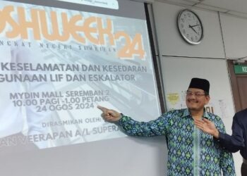 NOR Halim Hasan (kiri) menunjukkan poster Kempen Kesedaran Keselamatan Penggunaan Lif dan Eskalator di Seremban hari ini.-UTUSAN/NAZARUDIN SHAHARI.