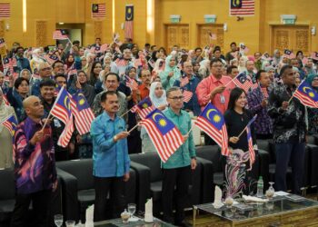 FAHMI Fadzil mengibarkan Jalur Gemilang pada Majlis Perhimpunan Bulanan Kementerian Komunikasi di Putrajaya. - UTUSAN/FAISOL MUSTAFA