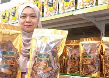 SITI Zahirah Ismail menunjukkan kerepek pisang keluarannya di RTC Gopeng. – UTUSAN/MEGAT LUTFI MEGAT RAHIM