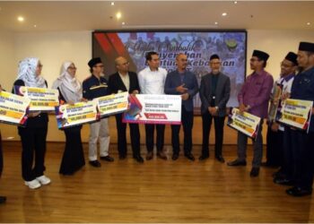 SYAMSUL Hazeman Md. Salleh (enam dari kanan) bersama wakil IPT semasa majlis simbolik penyerahan Skim Bantuan Kebajikan Siswa IPT di Ipoh hari ini. - UTUSAN