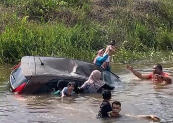 ORANG ramai menyelamatkan individu dalam kereta yang terbabas dalam parit di Jalan Selama - Bagan Serai kelmarin. - UTUSAN/MEDIA SOSIAL