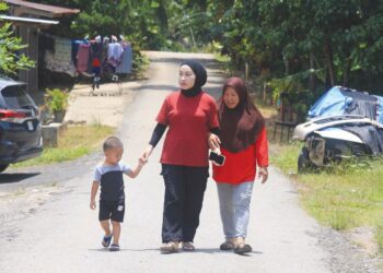 SITI Norelyana Kamarulzaman (tengah) berjalan sambil ditemani ibu serta anak saudaranya di Kampung Paloh 3, Gua Musang, Kelantan. 
– UTUSAN/KAMARUL BISMI KAMARUZAMAN