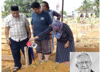 SEORANG ahli keluarga menyiram pusara Allahyarham Ahmad Mohd. Don di Tanah Perkuburan Islam Kassim Noor, Kampung Sungai Danga, Johor Bahru.