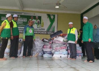 AHMAD Yahaya (dua kanan) melihat barangan keperluan untuk mangsa-mangsa banjir di Kompleks Pas Pokok Sena di Alor Setar.