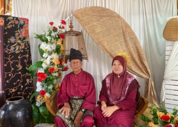 Yusry Mohamed Zuludin bersama isterinya diraikan seperti raja sehari dalam majlis persaraannya di Sekolah Kebangsaan Pulau Tawar, Jerantut, Pahang. - UTUSAN/HARIS FADILAH AHMAD