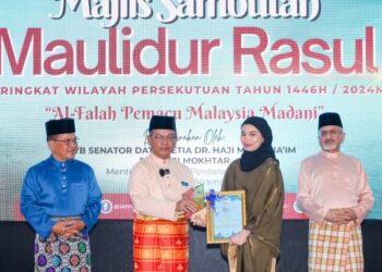 MOHD. Na’im Mokhtar menyampaikan Anugerah Khas Individu sempena Sambutan Maulidur Rasul Peringkat Wilayah Persekutuan kepada wartawan Utusan Malaysia, Nurul Irdina Sumali yang mewakili Siti Maisarah Sheikh Rahim di Kuala Lumpur, semalam.