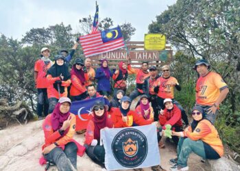MAHANI Meran (barisan belakang, empat dari kiri) bersama pendaki Team Harok Adventure ketika mengibarkan Jalur Gemilang di puncak Gunung Tahan di Jerantut, Pahang. baru-baru ini.