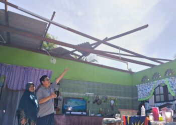 MOHD. Jaafar Shaari dan isteri, Rugayah Yahya menunjukkan  bumbung rumahnya yang diterbangkan angin, di Kampung Darat, Kijal, Kemaman, semalam. - UTUSAN/NIK NUR IZZATUL HAZWANI NIK ADNAN