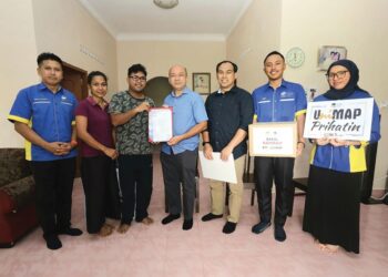 Zaliman Sauli (tengah) menyerahkan surat tawaran kemasukan ke Unimap kepada Suchanan Boon Aik di Kampung Paya Sidang, Alor Setar, Kedah semalam.