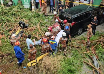 Anggota bomba mengeluarkan dua individu yang maut selepas kereta mereka dihempap pokok dan runtuhan konkrit di Lebuh Gereja, George Town, Pulau Pinang semalam.