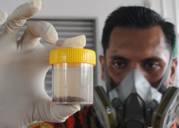 PEGAWAI Bomba Kanan ll Abdul Wahab Nasir daripada Hazmat Johor menunjukkan sampel air yang diambil dari Sungai Pandan yang berbau busuk di Kampung Melayu Pandan, Johor Bahru.