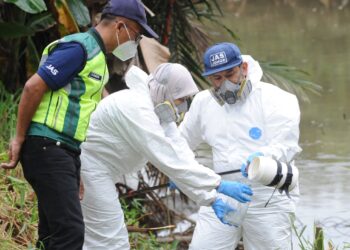 ANGGOTA  JAS Johor mengambil sampel air Sungai Pandan sambil diperhatikan oleh Mohd. Rashdan Topa (kiri) bagi mengenal pasti punca pencemaran bahan kimia di Kampung Melayu Pandan, Johor Bahru.