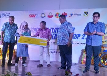 ZAINAL Eran menyerahkan cek  RM30,000 kepada Pemangku Pengetua SMK Sri Kukup, Siti Suanja Somiran bagi tabung pembangunan sekolah itu di Kompleks Penghulu Mukim Serkat, Pontian.