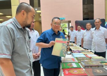 NIK Yusaimi Yussof (tengah)  menjunjukkan sebuah kitab tafsir al-Quran yang dirampas di UMK Kampus Bachok, Kelantan hari ini. UTUSAN/TOREK SULONG