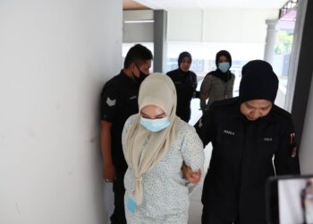 HANIS Faliana Mohd. Rosli (depan) dan Siti Hajar Mohd. Sukri (belakang) yang mengaku tidak bersalah mencederakan satu sama lain dibawa keluar dari Mahkamah Majistret Kuala Terengganu, hari ini. - UTUSAN/PUQTRA HAIRRY ROSLI