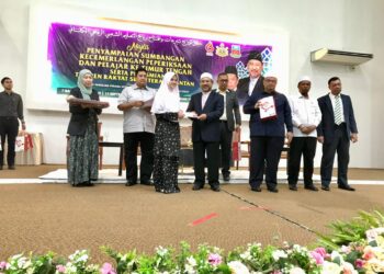 MOHD. Nassuruddin Daud (empat dari kanan) menyampaikan sumbangan kepada pelajar yang melanjutkan pengajian ke luar negara di Dewan Besar, YIK Tunjong, Kota Bharu, Kelantan hari ini.- UTUSAN/ ROSLIZA MOHAMED.