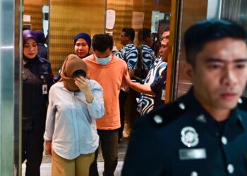 PASANGAN suami isteri yang dituduh atas mengedar dadah dibawa keluar dari  Mahkamah Majistret Kuala Terengganu, hari ini. - UTUSAN/PUQTRA HAIRRY ROSLI