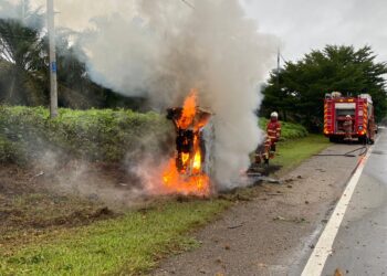 ANGGOTA bomba memadamkan kebakaran kereta Perodua Alza di Jalan Kota Tinggi-Johor Bahru berhampiran Taman Sri Saujana, Kota Tinggi.