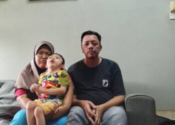 NORAZIFA Othman bersama anaknya, Muhammad Farhan Imran dan suaminya, Mohd. Fauzi Haron di rumah mereka di PPR Taman Perling, Johor Bahru.