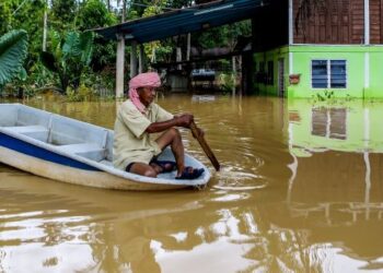 SEORANG penduduk, Ismail Mahmud, 72, menggunakan bot untuk keluar dari kawasan rumahnya yang dinaiki air banjir gelombang kedua setelah dilanda banjir kali pertama minggu lalu di Derang, Pokok Sena, Kedah, semalam. – UTUSAN/SHAHIR NOORDIN