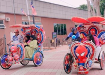 DUA pengayuh beca sedang membawa pelancong melalui kawasan hadapan Bangunan Madonna di Banda Hilir, Melaka. - UTUSAN/MUHAMMAD SHAHIZAM TAZALI