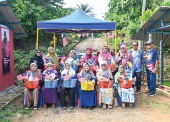 SEBAHAGIAN OKU dan golongan memerlukan yang diraikan Faizah Awang Boh (belakang, kiri) dan Mohamad Shahimi Ismail sempena sambutan Hari Kebangsaan ke-67 di Pekan Sehari Kampung Awah, Maran, Pahang. 
– UTUSAN/SHAIKH AHMAD RAZIF